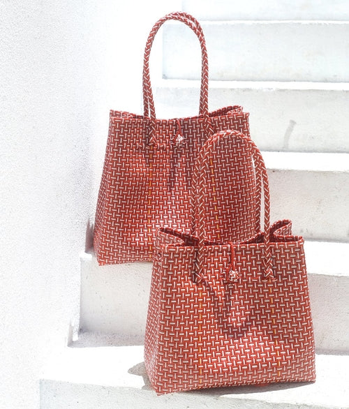 Two woven bags, one larger and one smaller, on a white surface.