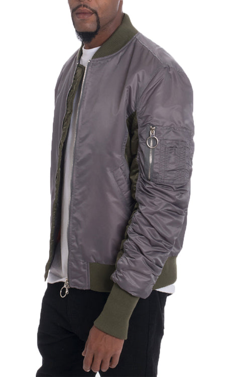 Gray bomber jacket with green accents worn by a person on a white background