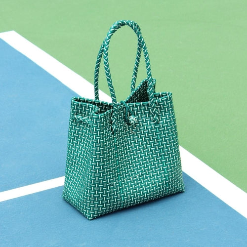 Green woven handbag on a blue and green checkered background