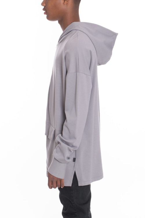 Person wearing a light gray hooded jacket on a white background