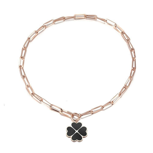 Rose gold bracelet with a black clover charm on a white background
