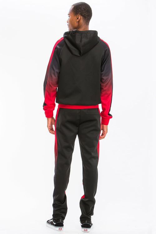 Person wearing a black and red tracksuit with gradient sleeves on a white background