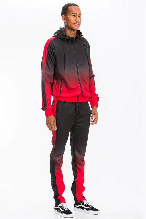 Person wearing a red and black gradient tracksuit on a white background