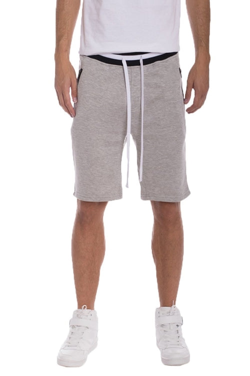 Person wearing gray shorts with a white drawstring, white shirt, and white sneakers on a white background