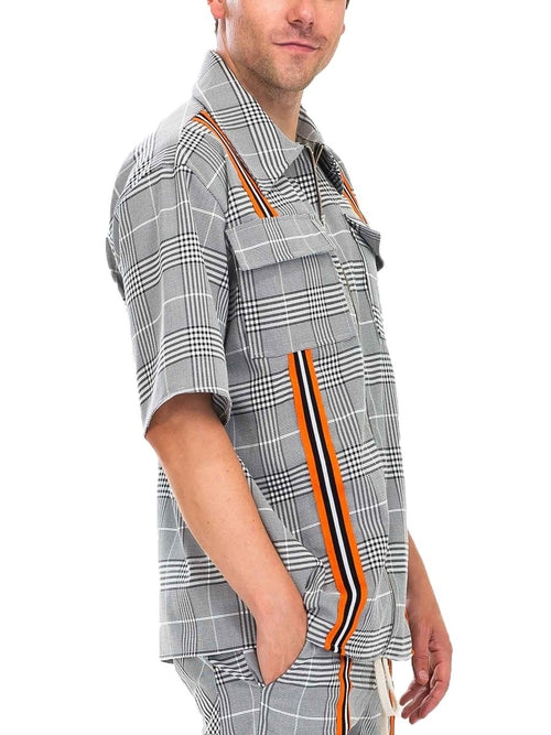 Person wearing a plaid shirt with suspenders on a white background