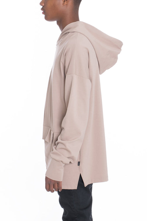Beige hoodie worn by a person on a white background