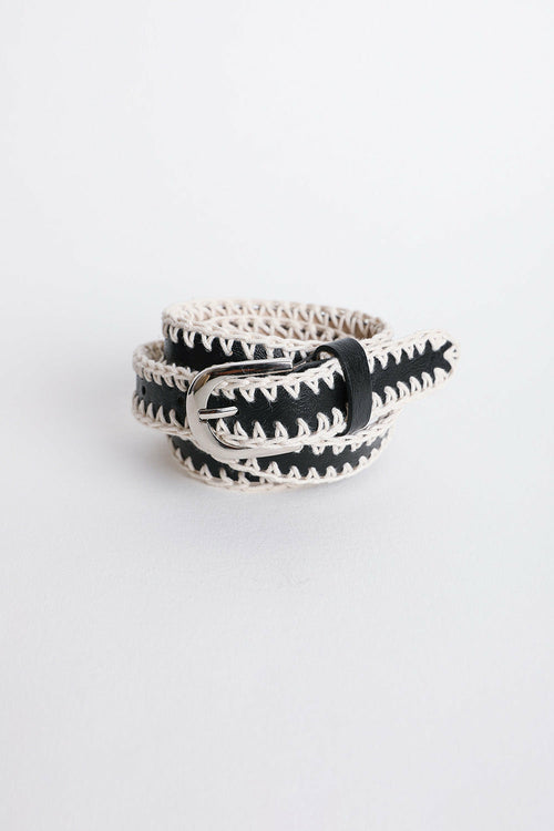 Black and white belt with a buckle on a light gray background