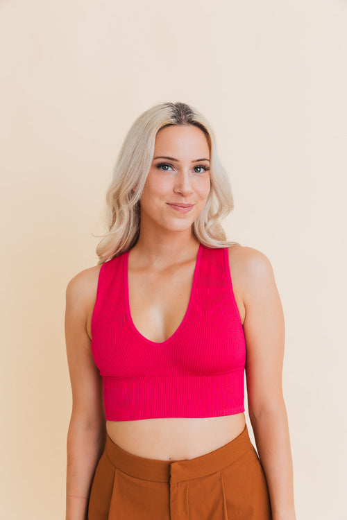 Woman wearing a bright pink top against a beige background