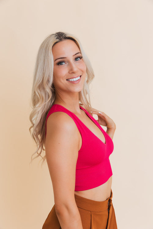 Woman wearing a bright pink top against a beige background