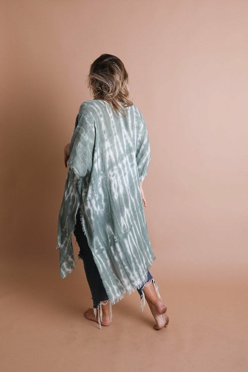 Person wearing a tie-dye kimono against a beige background