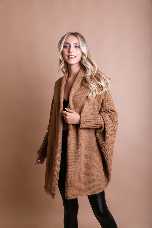 Woman wearing a brown coat against a beige background