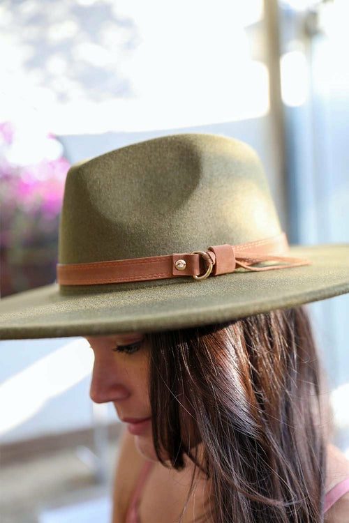 Person wearing a green hat with a brown band outdoors