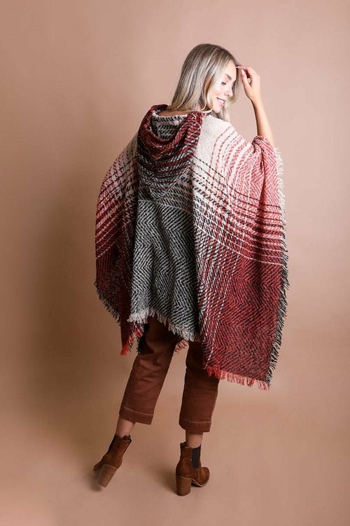 Woman wearing a patterned poncho against a beige background