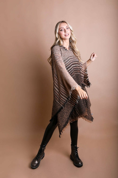 Woman wearing a brown patterned poncho against a beige background
