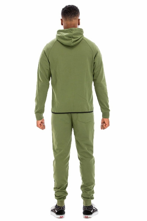 Person wearing a green tracksuit on a white background