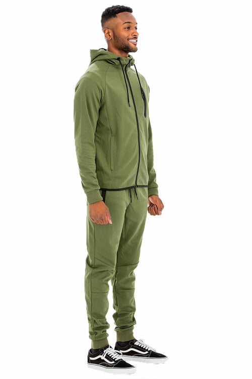 Man wearing a green tracksuit on a white background