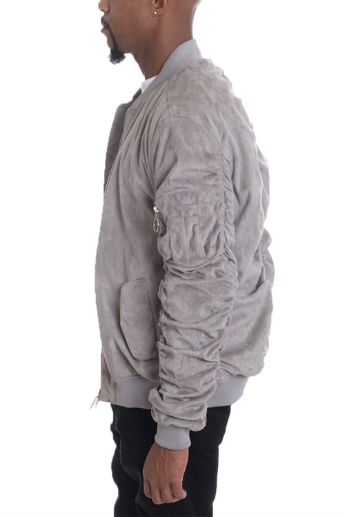 Man wearing a gray bomber jacket on a white background