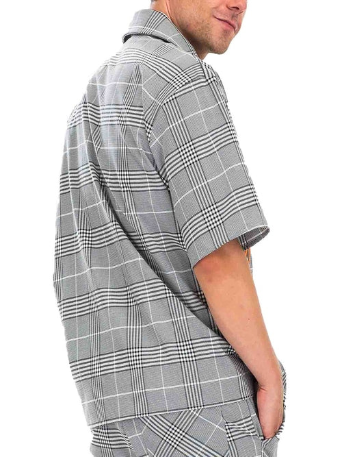 Man wearing a gray and white checkered shirt on a white background