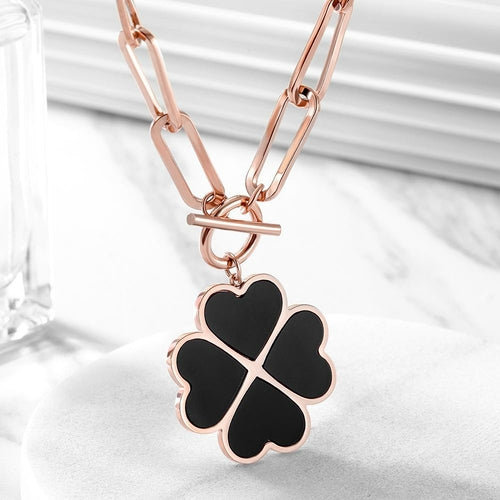 Rose gold necklace with a black clover pendant on a white background