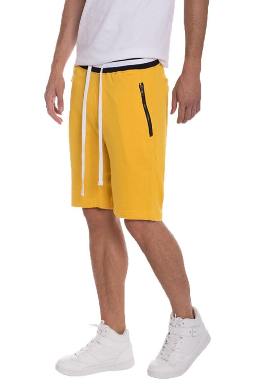 Yellow shorts with a zipper pocket on a white background