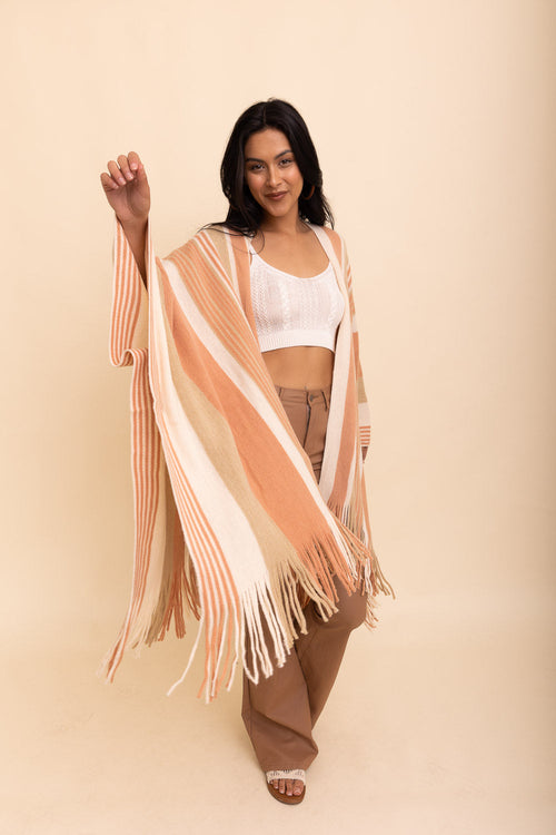 Woman wearing a striped kimono-style garment against a beige background