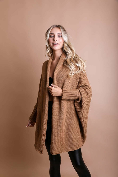 Woman wearing a brown coat against a beige background