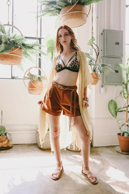 Woman in a stylish outfit with plants in the background