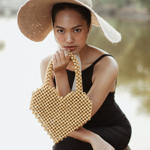 Woman holding a beaded handbag outdoors