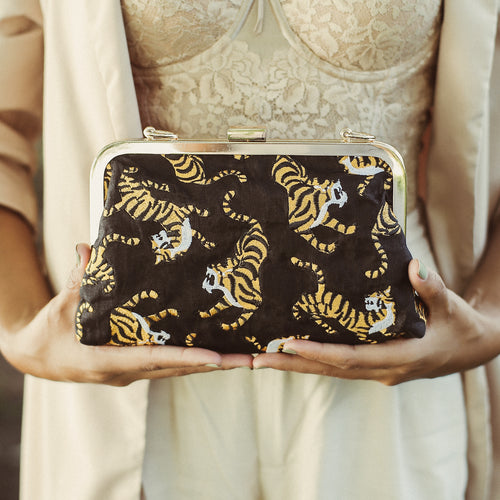Clutch bag with tiger pattern held by a person